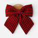 A large red and black buffalo plaid bow with a brown cardboard hanger, shown against a plain light gray background.