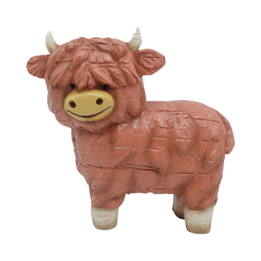 Toy figure of a brown cow with a smiling face on a white background