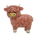 Toy figure of a brown cow with a smiling face on a white background