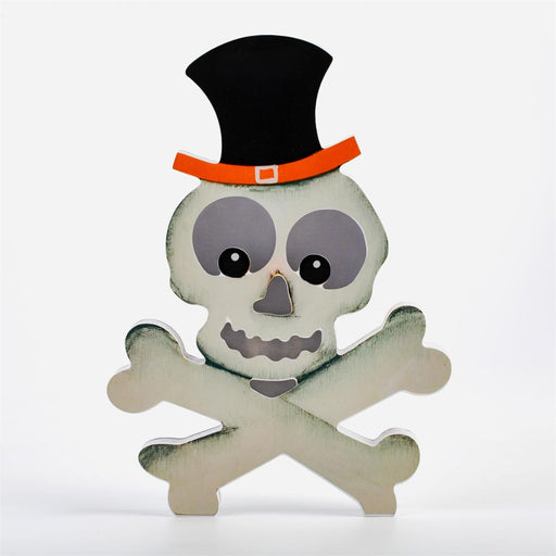 A decorative skull and crossbones cutout with a black top hat and orange band, shown on a plain light gray background.