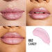 Four-panel close-up of lips wearing a glossy pink lip product, alongside a pink product swatch and the text '002 CANDY'.