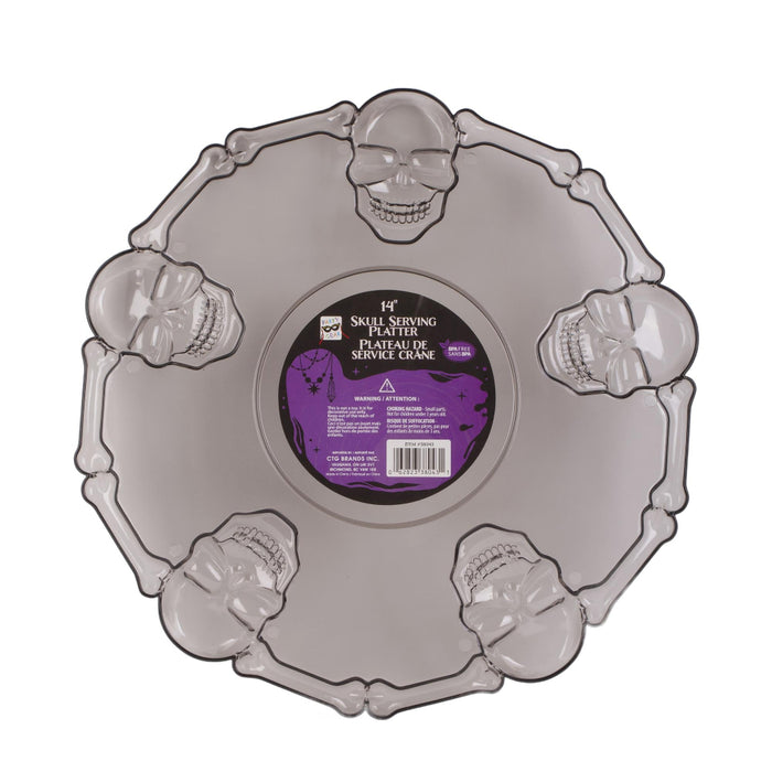 A Halloween-themed plastic serving platter shaped like a skull with decorative skull and bone motifs around the rim, featuring a purple and black center label.