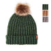 A dark green ribbed knit beanie with a fluffy brown and beige faux-fur pom-pom on top and a small brown leather brand tab on the cuff. Three color swatches are shown in the upper right corner against a white background.