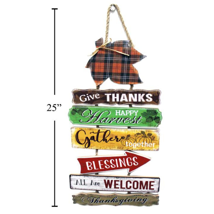 A rustic multi-tiered hanging sign with autumn-themed words including 'Give Thanks', 'Happy Harvest', 'Gather together', 'Blessings', 'All Are Welcome', and 'Thanksgiving'. A plaid turkey decoration hangs from the top, and a black measurement line on the left indicates a height of 25 inches.