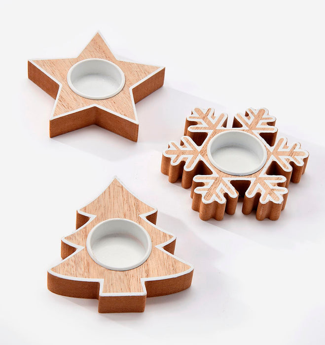 Three wooden decorative candle holders shaped like a star, Christmas tree, and snowflake, each with a white circular center, arranged on a clean white background.