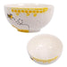 Two ceramic bowls with honeycomb and bee designs on a white background