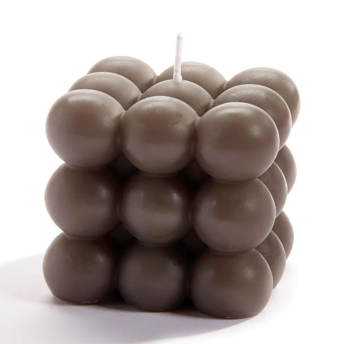 Cube-shaped candle made of small round candles on a white background