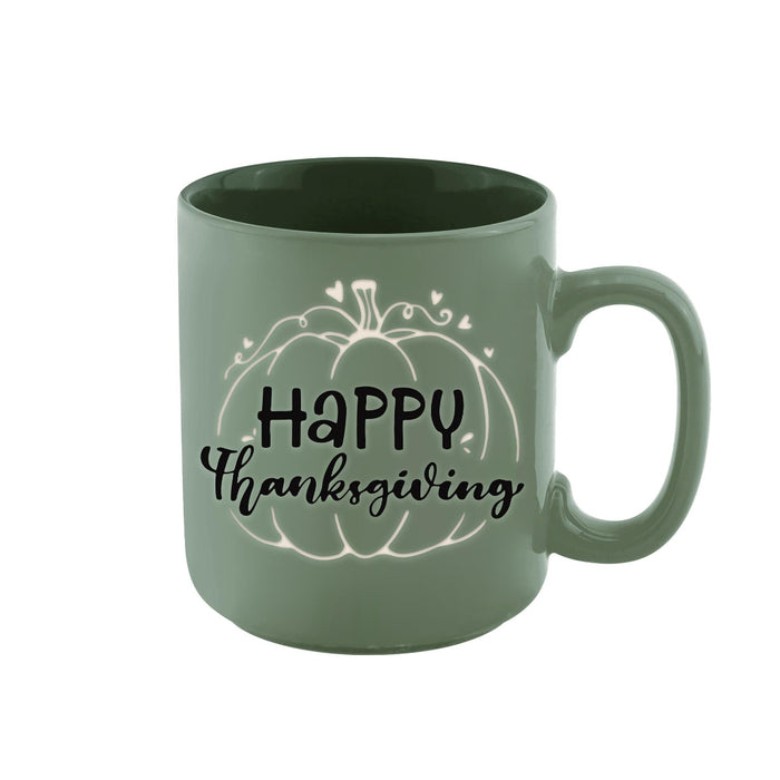 A sage green ceramic mug with a 'Happy Thanksgiving' pumpkin graphic printed on the side, set against a plain white background.