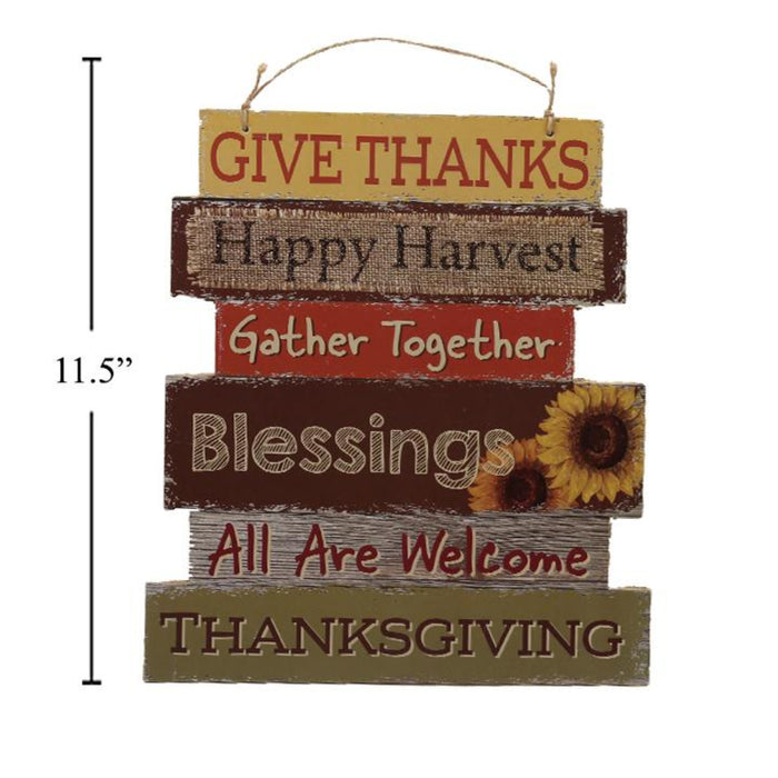 A rustic multi-layered wooden hanging sign with Thanksgiving-themed phrases including 'GIVE THANKS', 'Happy Harvest', 'Gather Together', 'Blessings', 'All Are Welcome', and 'THANKSGIVING'. The sign has a black height measurement marker on the left side indicating 11.