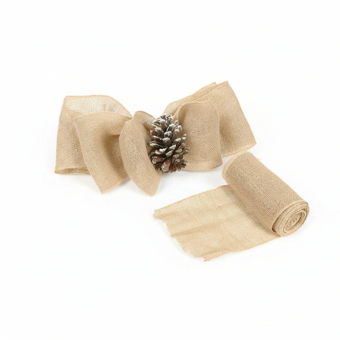 Natural burlap ribbon bow with a small frosted pinecone center, shown alongside a roll of matching burlap ribbon on a white background.