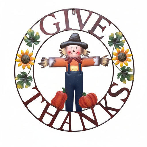 A circular autumn-themed sign with the words 'GIVE THANKS' in dark red lettering, surrounding a scarecrow, sunflowers, green leaves, and red pumpkins on a white background.