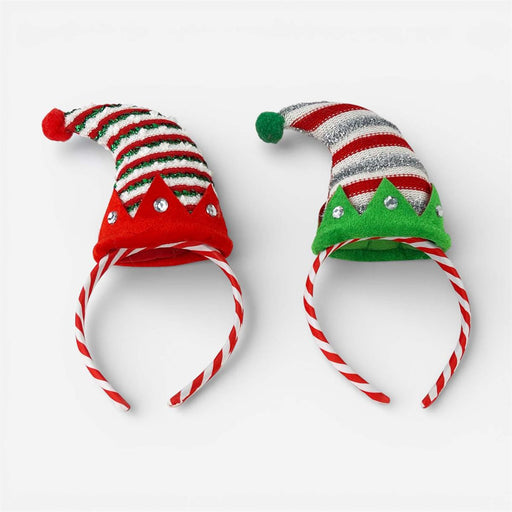 Two festive elf hat headbands on a white background. One is red and white striped with green accents and rhinestones, and the other is silver and white striped with green accents and rhinestones.