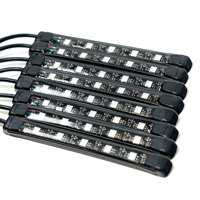 Six black LED light strips with attached black cables, arranged in a parallel stack on a white background.