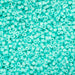 Turquoise glass beads on a turquoise background