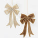 Two fuzzy fabric bow ornaments hanging against a plain white background, one in cream and one in tan.