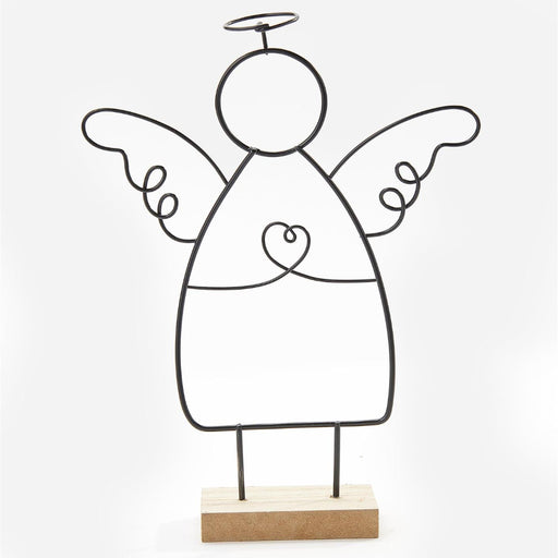 A minimalist black metal wire angel figurine with wings, a halo, and a heart on the chest, standing on a light natural wood base against a plain white background.