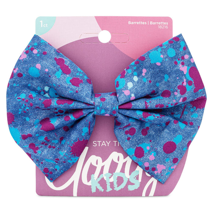 Blue splatter-print fabric bow barrette from Goody Kids, attached to pink packaging with “Stay Tight” technology label.