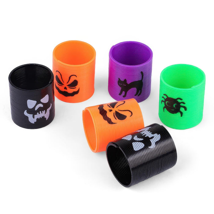 Six plastic spiral toy tubes in black, orange, purple, and green, each printed with a different Halloween-themed graphic including a skull, jack-o'-lantern, cat, spider, and ghost.