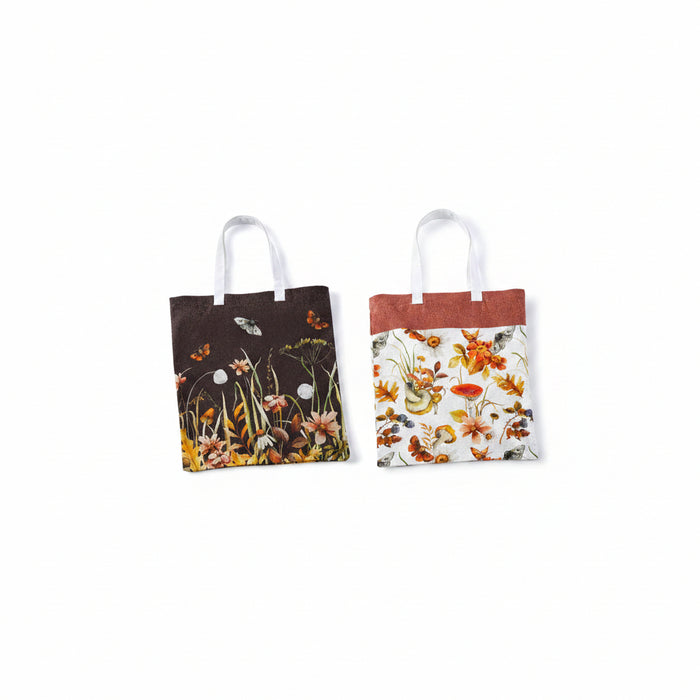Two fabric tote bags with white handles, displayed side by side against a white background. The left bag has a dark brown top half with a floral and butterfly pattern in the lower half.
