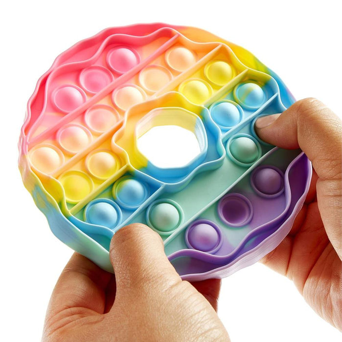 Colorful pop-it fidget toy held by a hand on a white background