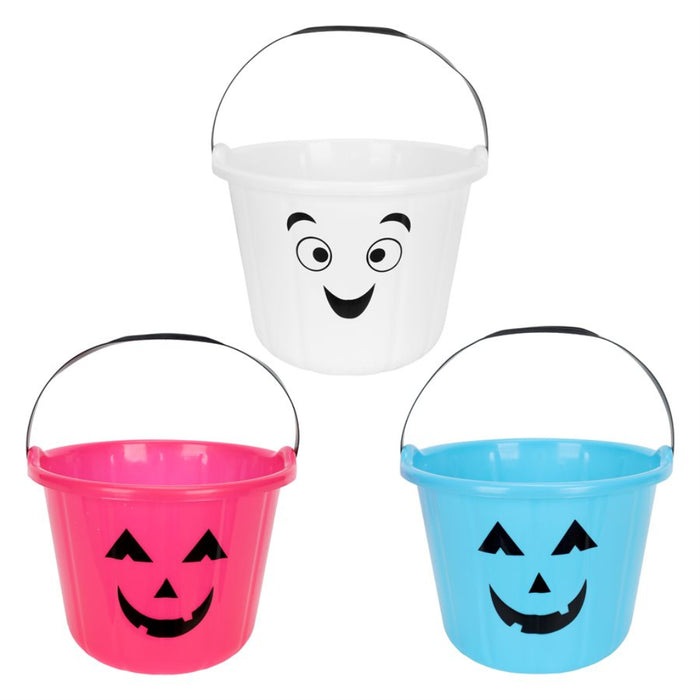Three plastic Halloween bucket toys on a white background: one white bucket with a black handle and black jack-o'-lantern face, one pink bucket with a black handle and black face, and one light blue bucket with a black handle and black face.