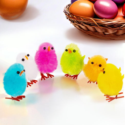 Colorful fluffy chicks in front of a basket of Easter eggs on a white background