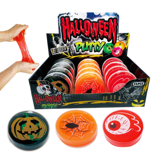 Halloween-themed plastic putty discs displayed in a retail box with three sample discs in front. A hand is stretching red putty on the left.