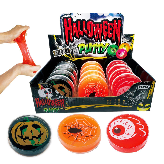 Halloween-themed plastic putty discs displayed in a retail box with three sample discs in front. A hand is stretching red putty on the left.