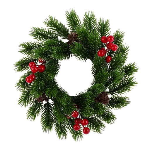 A green artificial pine wreath decorated with clusters of red berries and brown pinecones, isolated on a white background.