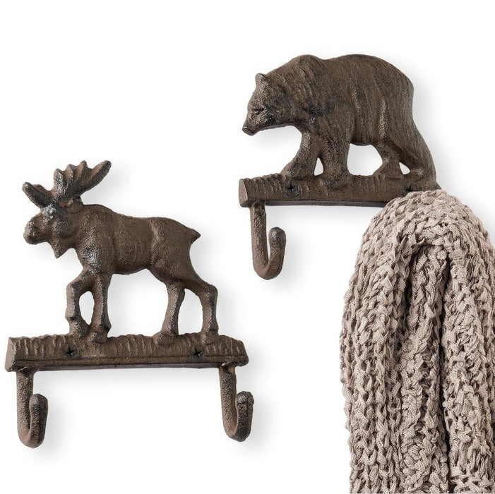 Two wall hooks shaped like a moose and a bear with a knitted item hanging on one of them.