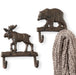 Two wall hooks shaped like a moose and a bear with a knitted item hanging on one of them.