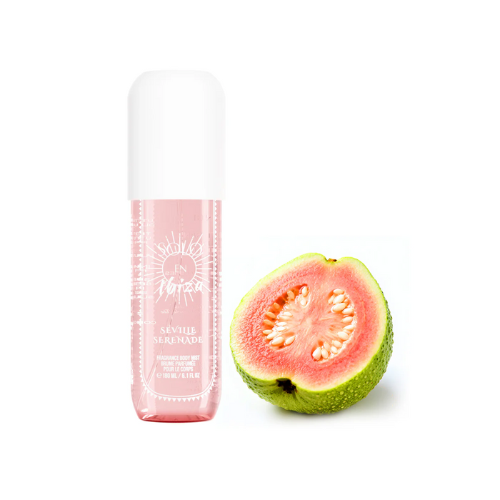 Pink bottle of skincare product next to a halved guava on a white background