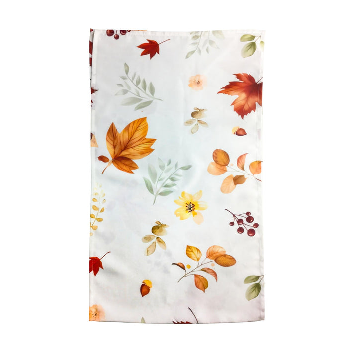 A rectangular white fabric item, likely a napkin or small towel, featuring a scattered autumn leaf and berry pattern in orange, red, yellow, and green, displayed flat against a white background.