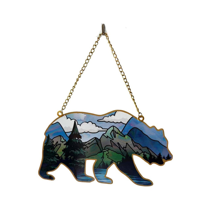 Decorative wall hanging with bear silhouette and mountain landscape design on a white background.
