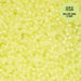 Close-up of small lime green beads with a label indicating 'Glow in the Dark' on a matching background.